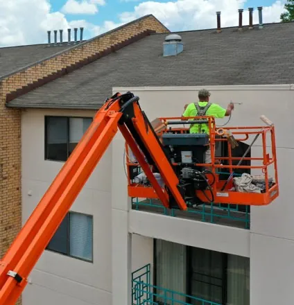 PHP Commercial Painting crew applying an exterior coating from an aerial lift